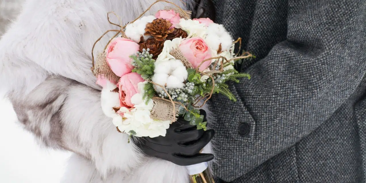 Couple vêtu de manteau pour leur mariage d'hiver