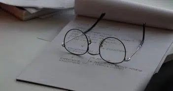 black framed eyeglasses on top of white printing paper