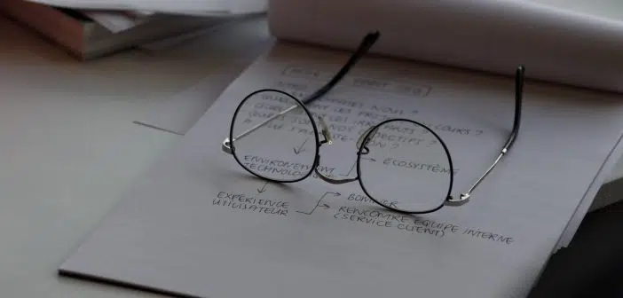 black framed eyeglasses on top of white printing paper