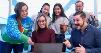 un groupe d'employés et leur manager regardant l'écran d'un PC
