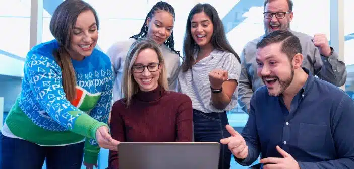 un groupe d'employés et leur manager regardant l'écran d'un PC