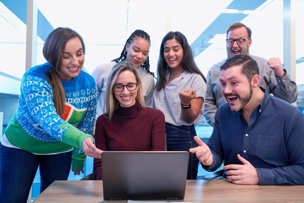 un groupe d'employés et leur manager regardant l'écran d'un PC